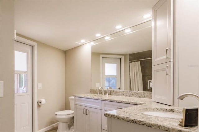 bathroom featuring vanity, toilet, plenty of natural light, and curtained shower