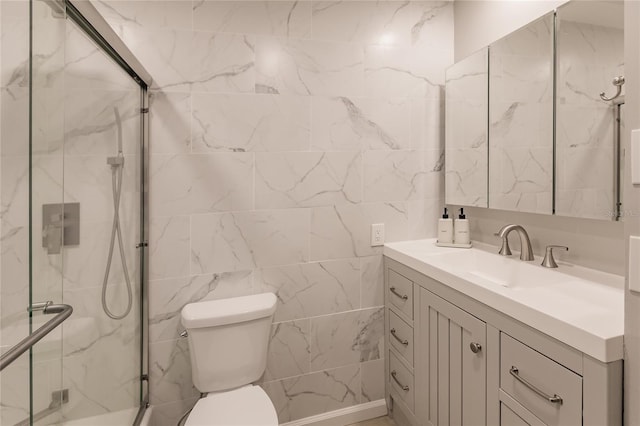 bathroom with vanity, toilet, and a shower with door