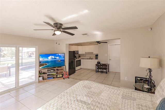 bedroom with ceiling fan, black refrigerator, light tile patterned floors, and access to outside