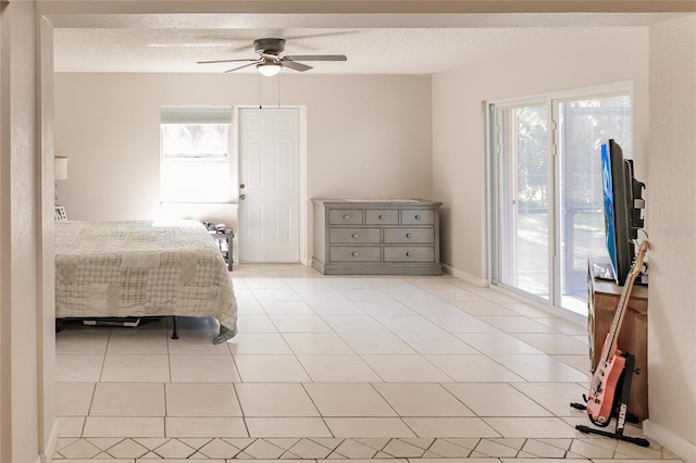 unfurnished bedroom featuring ceiling fan, access to exterior, light tile patterned floors, and a textured ceiling