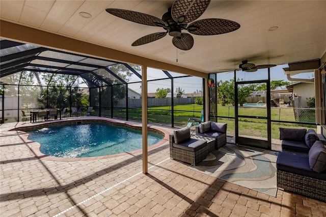 view of swimming pool with glass enclosure, ceiling fan, a yard, an outdoor hangout area, and a patio area