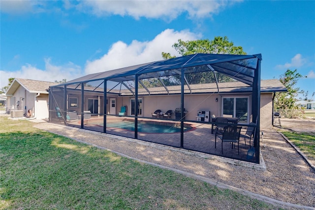 back of house with a yard, a patio, and a lanai