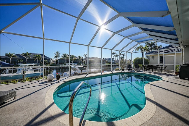 view of pool with glass enclosure, a water view, and a patio