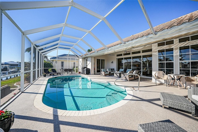 view of swimming pool featuring a patio, ceiling fan, and a lanai