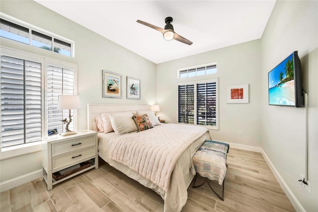 bedroom featuring multiple windows, ceiling fan, and light wood-type flooring