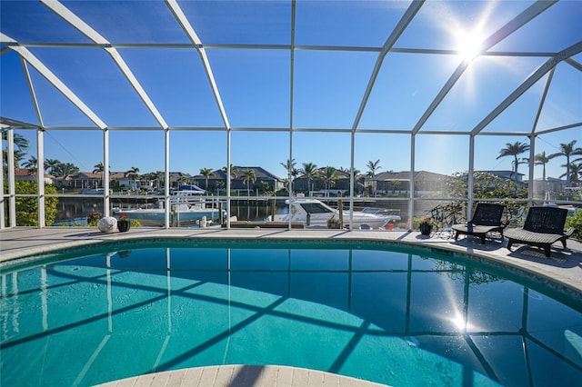 view of swimming pool with a lanai and a water view