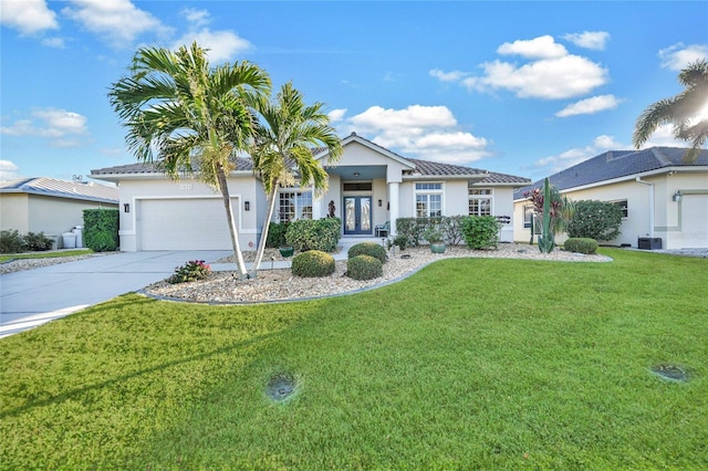 view of front of home with central air condition unit, french doors, a front yard, and a garage