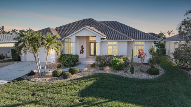 view of front of house with a garage and a lawn