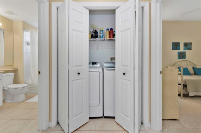 washroom featuring washing machine and dryer and light tile patterned floors