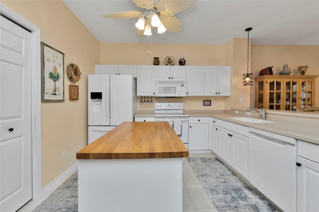 kitchen featuring a center island, sink, butcher block countertops, white appliances, and white cabinets