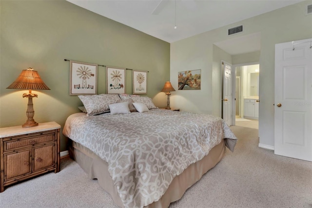 bedroom featuring ensuite bathroom, ceiling fan, and light carpet