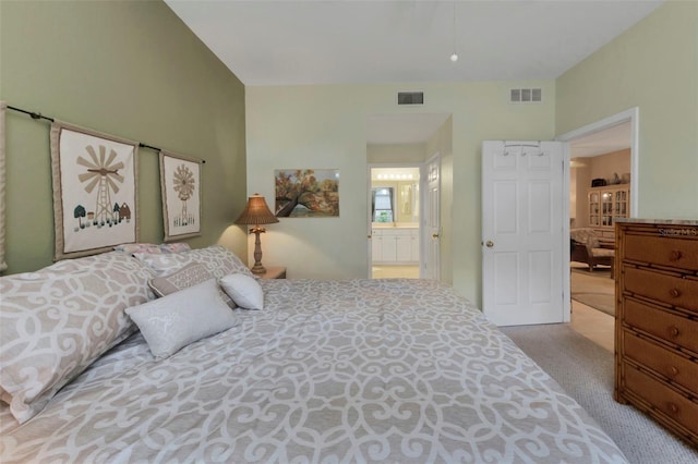 bedroom featuring light carpet and ensuite bath