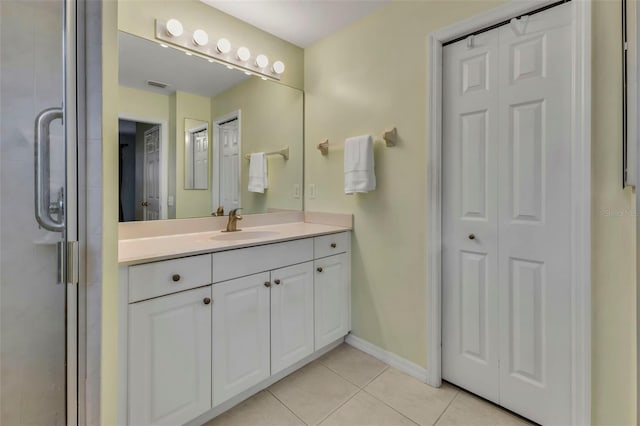 bathroom featuring tile patterned flooring, vanity, and a shower with shower door