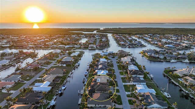 aerial view at dusk featuring a water view