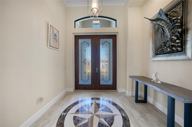 foyer entrance with crown molding and french doors