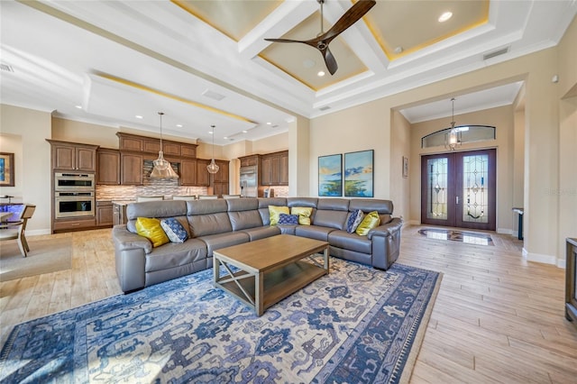 living room with french doors, ornamental molding, ceiling fan, light hardwood / wood-style flooring, and coffered ceiling