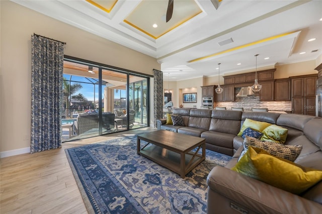 living room with beamed ceiling, ornamental molding, ceiling fan, light hardwood / wood-style flooring, and coffered ceiling