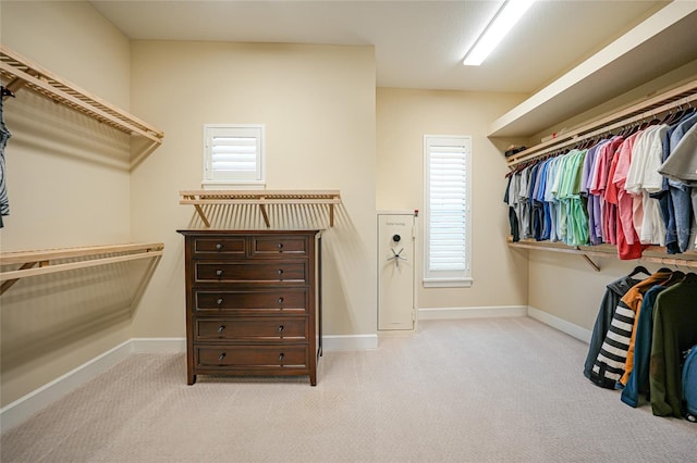 walk in closet with light carpet