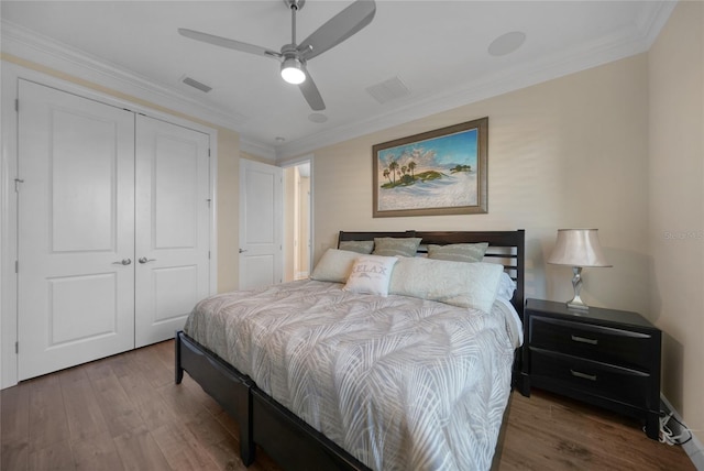 bedroom with ceiling fan, ornamental molding, a closet, and hardwood / wood-style floors