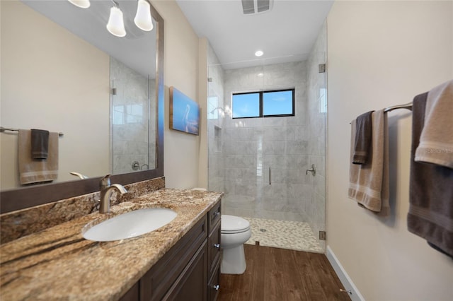 bathroom with toilet, vanity, wood-type flooring, and an enclosed shower