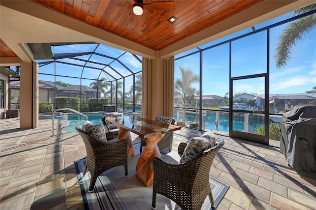 sunroom / solarium featuring wood ceiling, a water view, and a pool