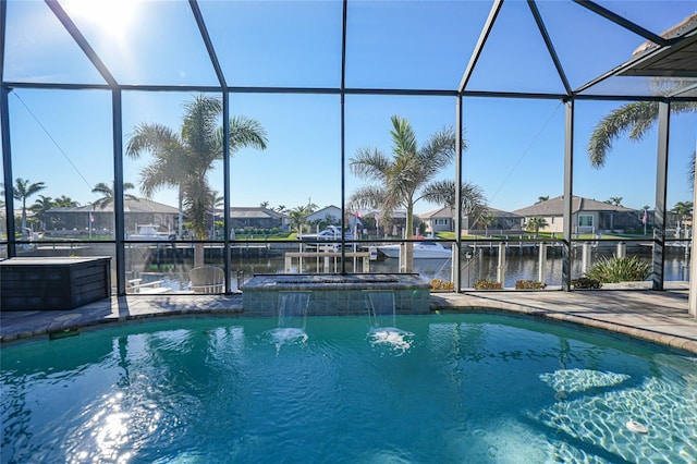 view of swimming pool featuring a lanai, pool water feature, a patio area, and a water view