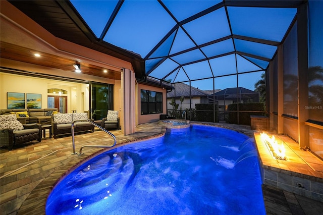 view of pool featuring a patio area, an in ground hot tub, pool water feature, an outdoor living space with a fire pit, and a lanai