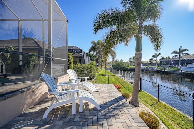 view of patio featuring a lanai and a water view