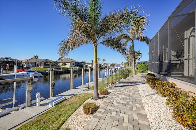 view of dock with a lanai and a water view