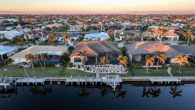 aerial view at dusk featuring a water view