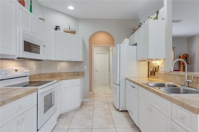 kitchen featuring white cabinets, white appliances, light tile patterned flooring, and sink