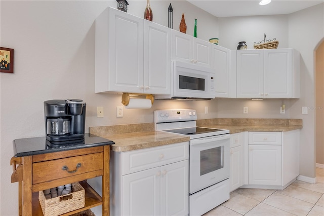 kitchen featuring white cabinetry, light tile patterned floors, and white appliances