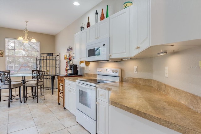 kitchen with white appliances, light tile patterned floors, white cabinets, a chandelier, and hanging light fixtures