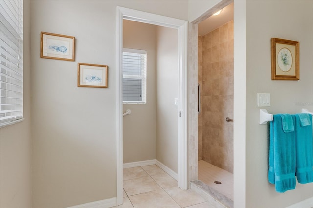 bathroom featuring tile patterned flooring and a tile shower