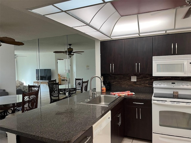 kitchen featuring sink, decorative backsplash, light tile patterned floors, dark brown cabinets, and white appliances