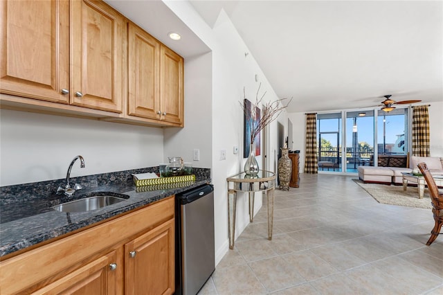 kitchen with floor to ceiling windows, dishwasher, dark stone countertops, ceiling fan, and sink