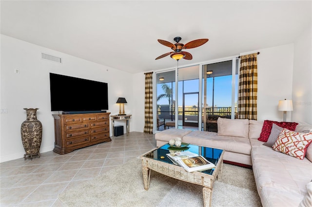 living room featuring ceiling fan, a wall of windows, and light tile patterned floors