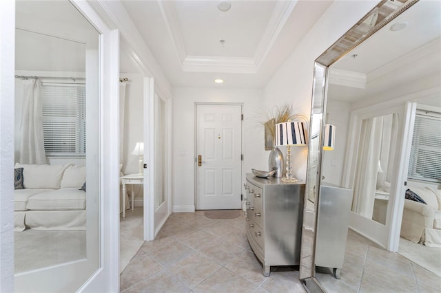 tiled entrance foyer featuring a tray ceiling and crown molding