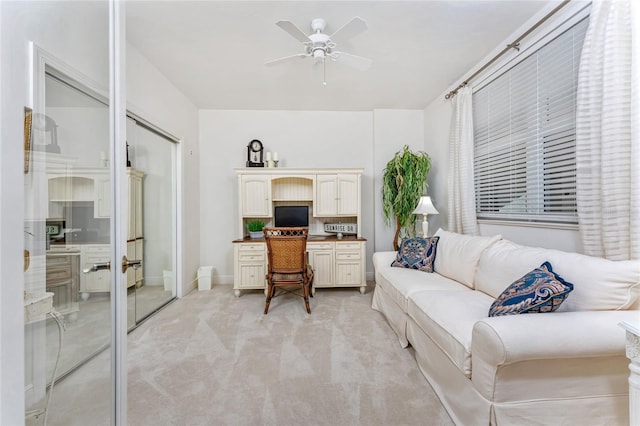 carpeted office space featuring ceiling fan