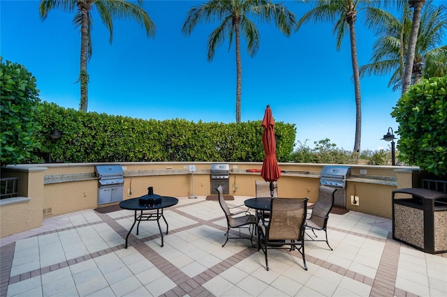 view of patio with exterior kitchen, grilling area, and a fire pit