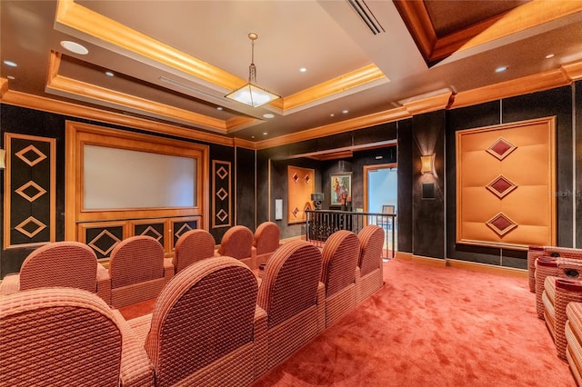 carpeted home theater featuring ornamental molding and a tray ceiling