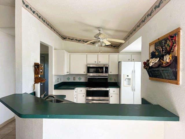 kitchen with light tile patterned floors, tasteful backsplash, appliances with stainless steel finishes, a sink, and a peninsula