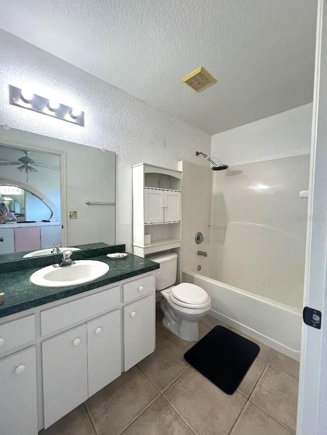 bathroom with a textured ceiling, a textured wall, visible vents, shower / washtub combination, and tile patterned floors