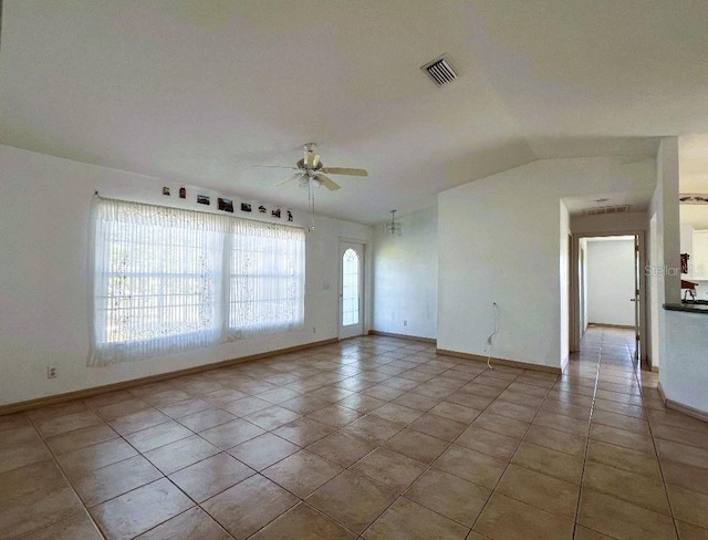 unfurnished room with visible vents, baseboards, ceiling fan, tile patterned flooring, and vaulted ceiling