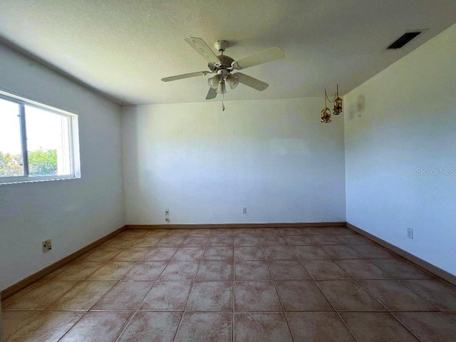 unfurnished room with baseboards, visible vents, ceiling fan, and light tile patterned flooring