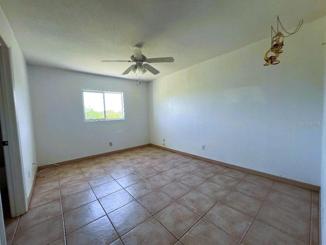 empty room with a ceiling fan and baseboards