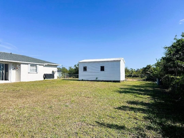 view of yard with fence and an outdoor structure