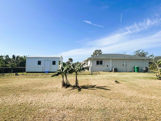 exterior space with a lawn, fence, and central AC