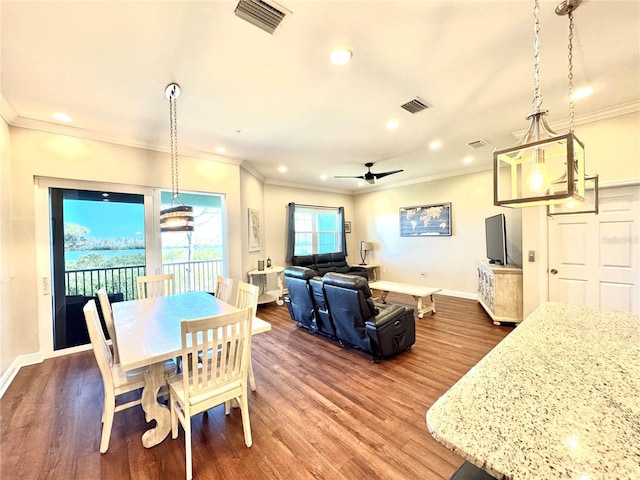 dining area with ceiling fan, crown molding, and dark wood-type flooring