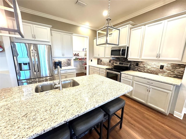 kitchen featuring a kitchen bar, white cabinetry, sink, and stainless steel appliances